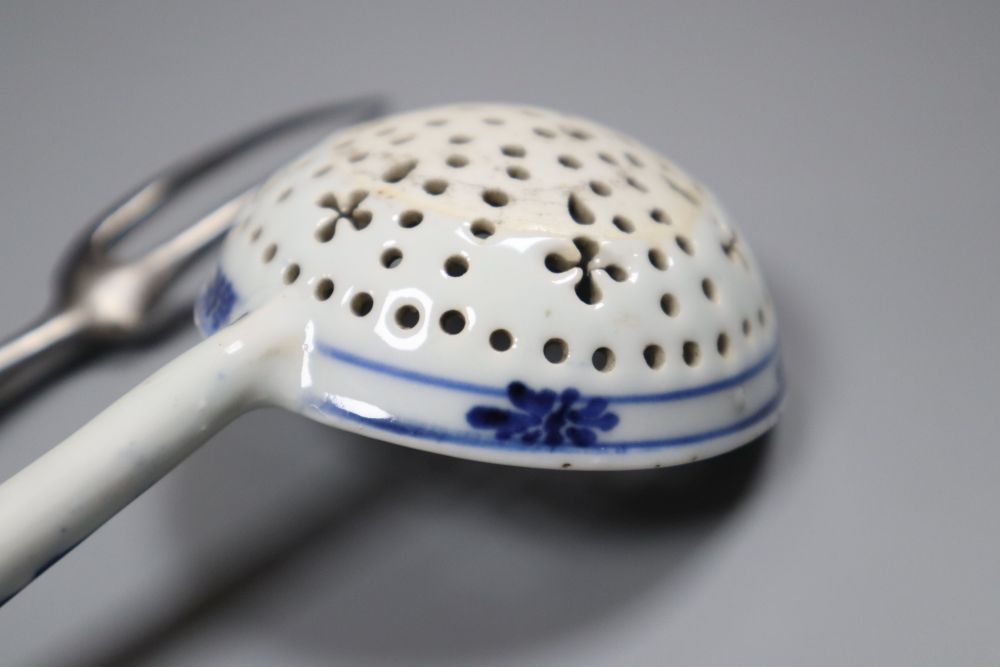A Bow pistol grip blue and white handled fork, c.1770, 23cm, and a Continental porcelain blue and white strainer ladle, 17cm